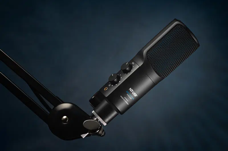 Microphone on boom arm with blue background representing podcast recording